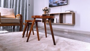 A modern living room with a sofa, a wooden coffee table, a TV, and a bookshelf. - Constatia Homes (Kampala)