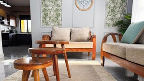 A modern living room with a sofa, two wooden side tables, and a patterned rug. - Constatia Homes (Kampala)