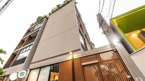Un edificio moderno con fachada plana, entrada de listones de madera y un cartel que indica 'joão ramalho, 1304'.