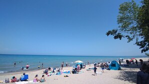 En strand med mennesker, telte og strandstole.