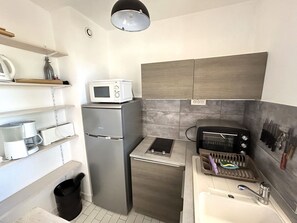 Eine kompakte Küche mit Mikrowelle, Toaster und Spüle.