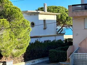 A building with a white facade, a chimney, and a small window. - Apartment near beach with parking - 4 guests (Argelès-sur-Mer)