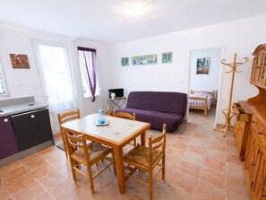A compact living space with a dining table, chairs, a sofa, a television, and a coat rack. - Single-storey House - 600m Beach & Center, Parking (La Tranche-sur-Mer)
