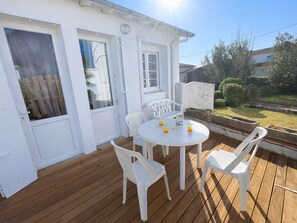 A white house with a wooden deck, white chairs, and a round table. - Single-storey House - 600m Beach & Center, Parking (La Tranche-sur-Mer)