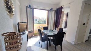 Een eethoek met een tafel, stoelen en een televisietoestel.