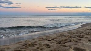 Een strand met een zandstrand en golven.