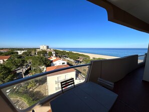 Ein Balkon mit Blick auf Strand und Gebäude.