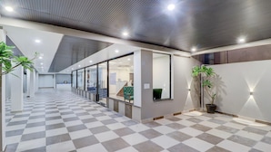 A spacious corridor with checkered flooring, glass walls, and potted plants. - Super Deluxe Room Hotel EL Portrait (Dehradun)