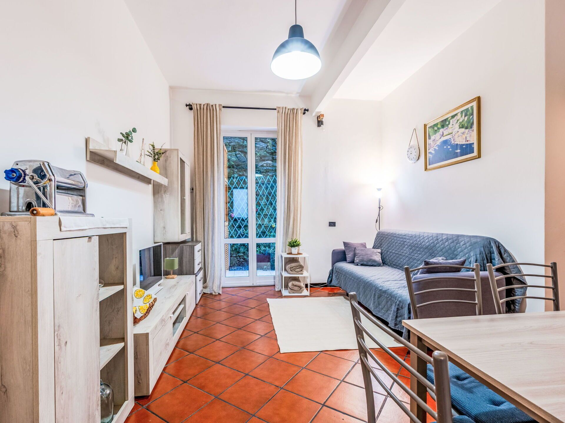 Ett kompakt bostadsutrymme med ett litet kök, en matplats och en soffa.