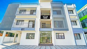 A modern hotel building with a prominent 'HOTELO' sign, multiple balconies, and a glass entrance. - Deluxe Kalamassery Near Medical College (Kanayannur)