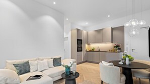 A modern living room with a sofa, coffee table, and dining area. - Experience Luxury at Ocean's Retreat in Westerland, Sylt (Sylt)