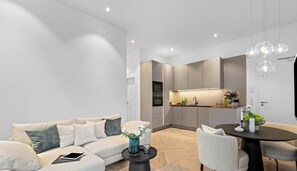 A modern living room with a sofa, coffee table, and dining area. - Experience Luxury at Ocean's Retreat in Westerland, Sylt (Sylt)