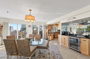 A modern kitchen with a glass island, wooden cabinets, and a view of the beach. - Beautiful Ocean Block home with fantastic views and a Hot Tub! (DEWEY BEACH)