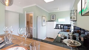 Una cocina moderna con comedor, refrigerador y cafetera.