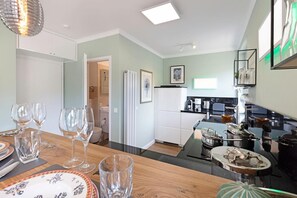 A modern kitchen with a dining area, a refrigerator, and a coffee maker. - Comfortable vacation apartment Dünenloft with balcony in List on Sylt with dune view (List auf Sylt)
