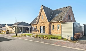 A residential area with houses featuring pitched roofs and brick exteriors. - Deichvilla Weitblick – Exclusive New-Build with Unobstructed Dike Views (Büsum)