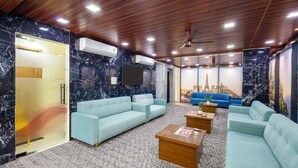 A modern hotel lobby with marble walls, a wooden ceiling, and a seating area with sofas and coffee tables. - RV Grand (Hyderabad)