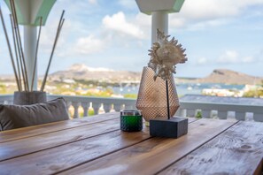 A wooden table with a decorative object, a green candle, and a black box. - The View The Ambassador (Jan Thiel)