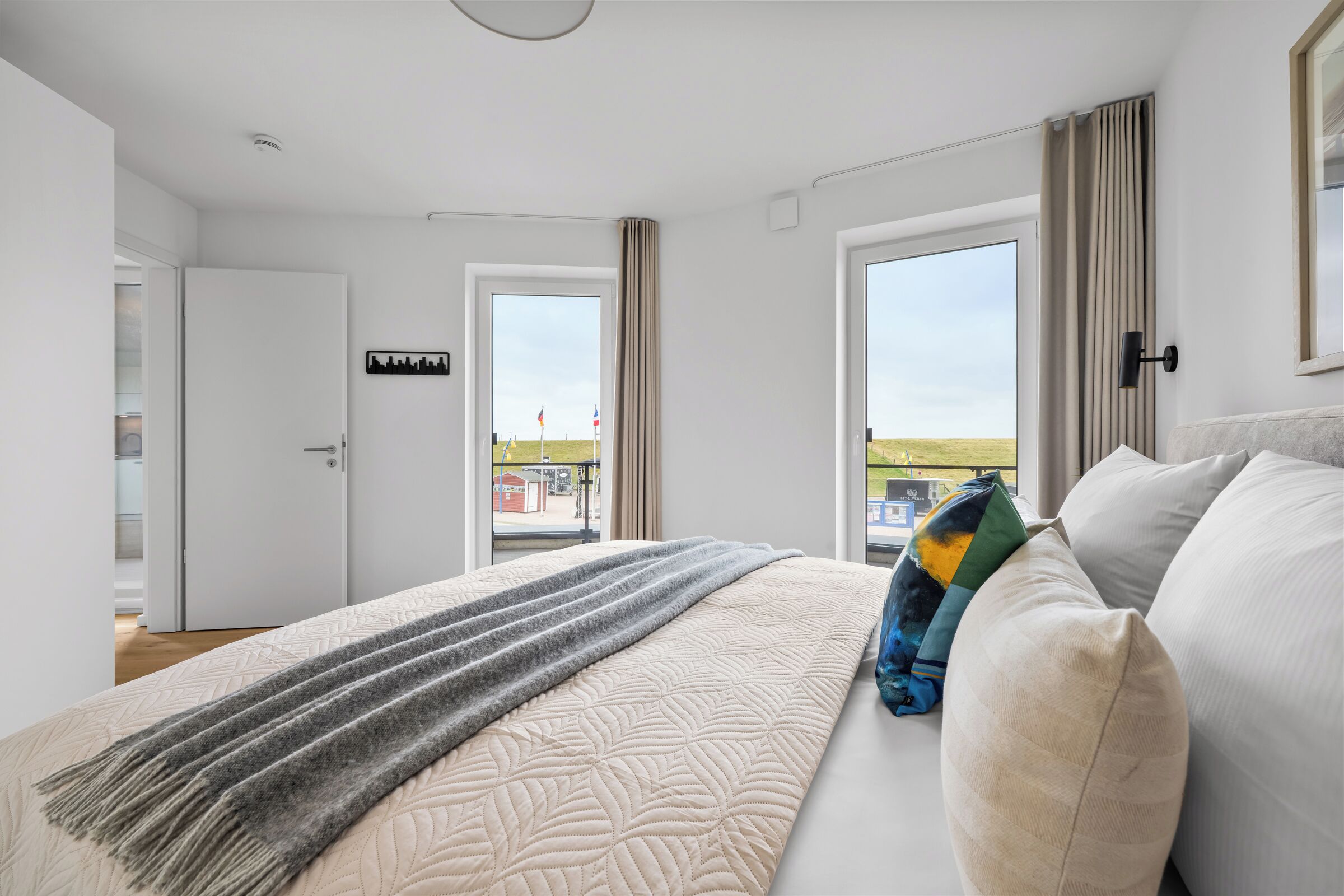 Een slaapkamer met een bed, uitzicht en een deur met een bordje.
