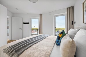 A bedroom with a bed, a view of the outside, and a door with a sign. - The View A03 Deichblick - Balcony, garden furniture, elevator, shared Sauna (Dagebüll)