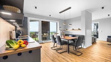 A modern kitchen with a wooden countertop, a dining area with a table and chairs, and a view of the outdoors.