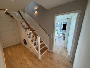 Eine Treppe mit Holzboden und weißen Geländern, die zu einer Aussichtsplattform führt.