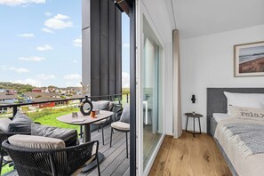 Ein Balkon mit Tisch, Stühlen und Blick auf eine Wohngegend.