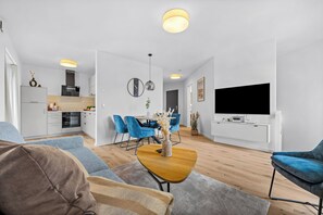 Ein modernes Apartment mit Küche, Essbereich und Wohnzimmer.