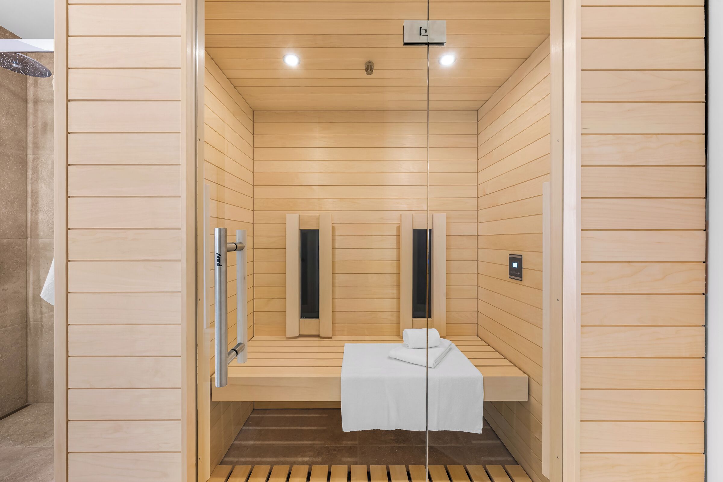 Eine Sauna mit Holzwänden, einer Sitzbank und einem Handtuch.