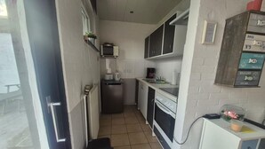 A compact kitchen with a microwave, toaster, and small refrigerator. - ERNST vacation home close to the Frisian beach in Tossens for the whole family (Butjadingen-Tossens)