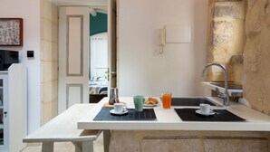 Een keuken met een spoelbak, een koffiezetapparaat en een ontbijtarrangement op het aanrecht.
