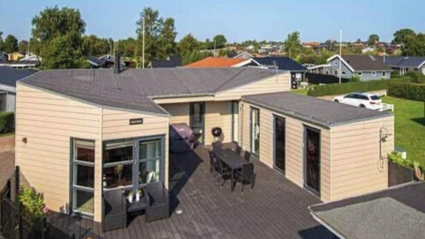 A single-story house with a patio area, a garage, and a visible front door. - 4 Star Holiday Home in Juelsminde (Juelsminde)