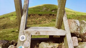 A wooden viewing platform with a clear view of a grassy hill and rocky terrain. - Tranquil retreat in idyllic Wooler, Northumberland National Park, pet friendly (Wooler)