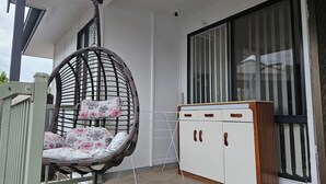 A room with a hanging chair, a cabinet, and a window. - Spacious 3‑Bedroom | Family & Work Stay | Near Campbelltown Hospital (Airds)