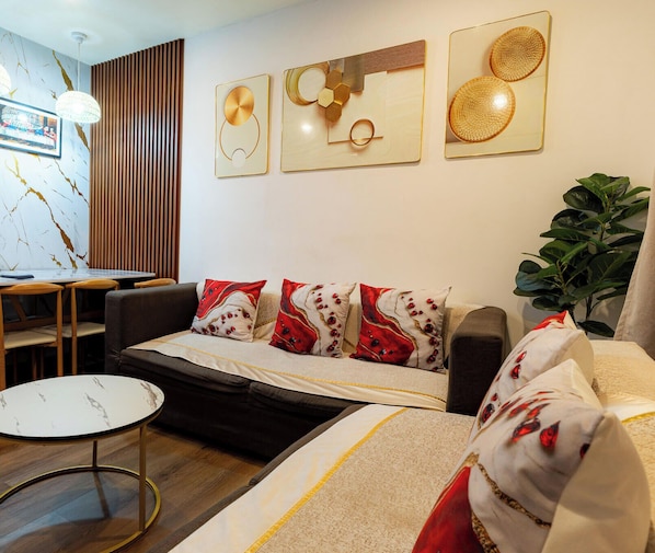 Una sala moderna con sofá, una mesa de centro y un comedor con sillas.