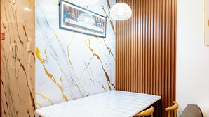 A dining area with a marble wall, wooden paneling, and a framed picture. - Peaceful 2-bedroom condo in wonderful Baguio getaway (Baguio)