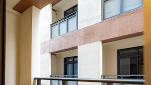 A multi-story building with a balcony and a glass railing. - Peaceful 2-bedroom condo in wonderful Baguio getaway (Baguio)
