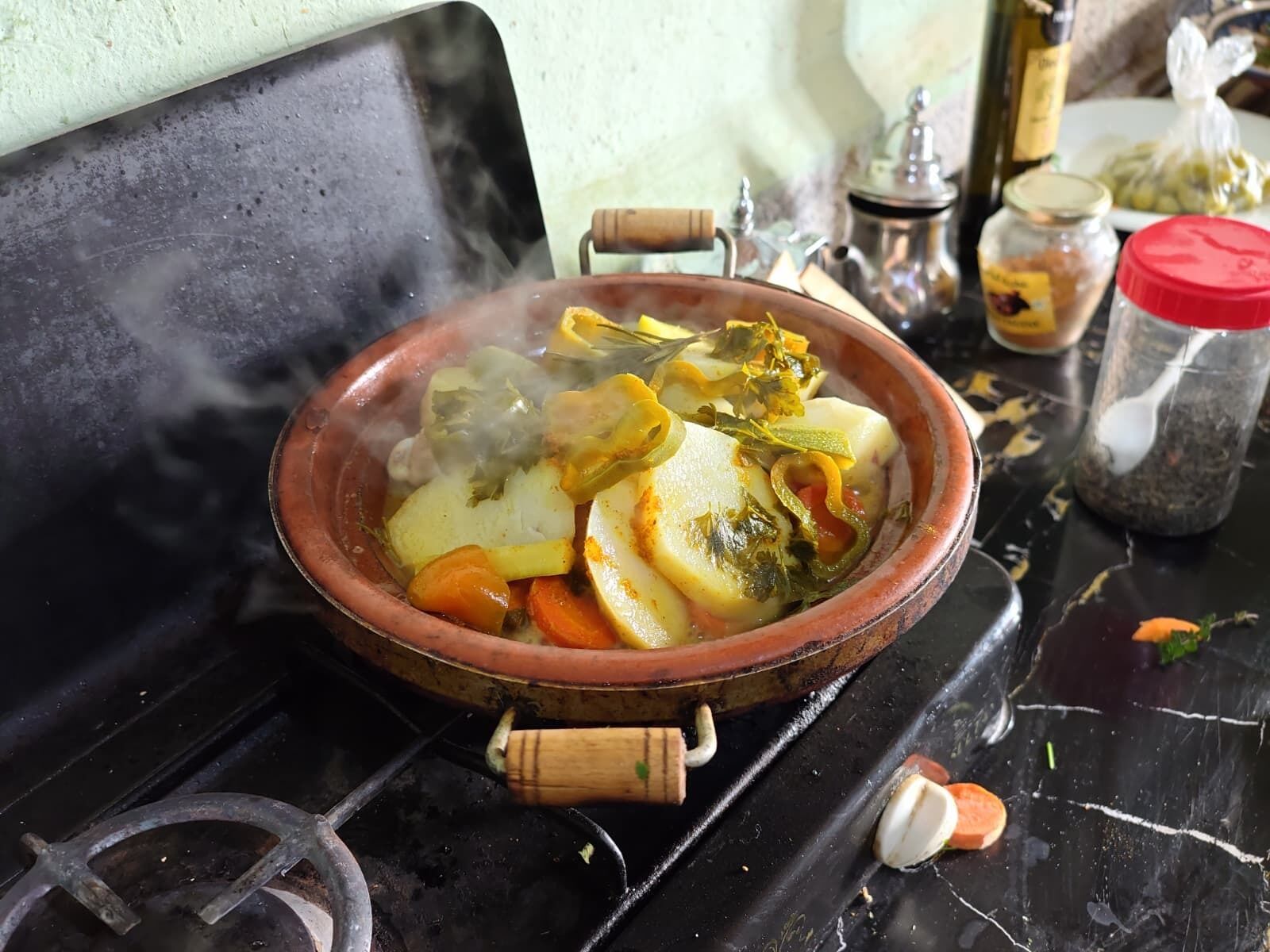A traditional clay pot with food on a stove.