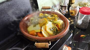 A traditional clay pot with food on a stove.