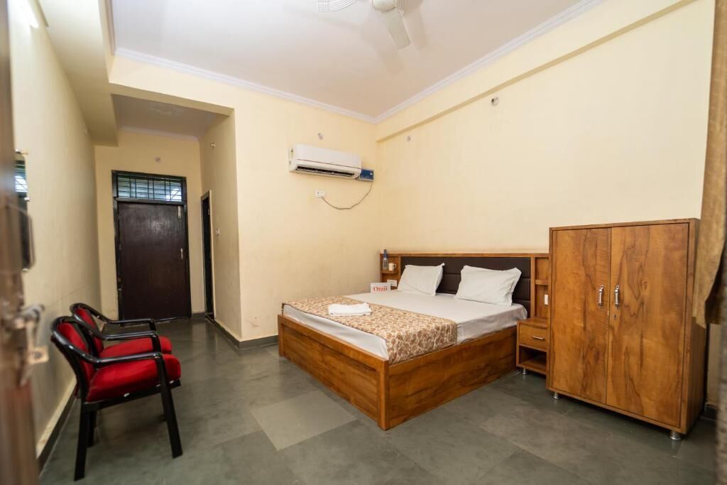 Un dormitorio con cama, armario, silla y equipo de aire acondicionado.