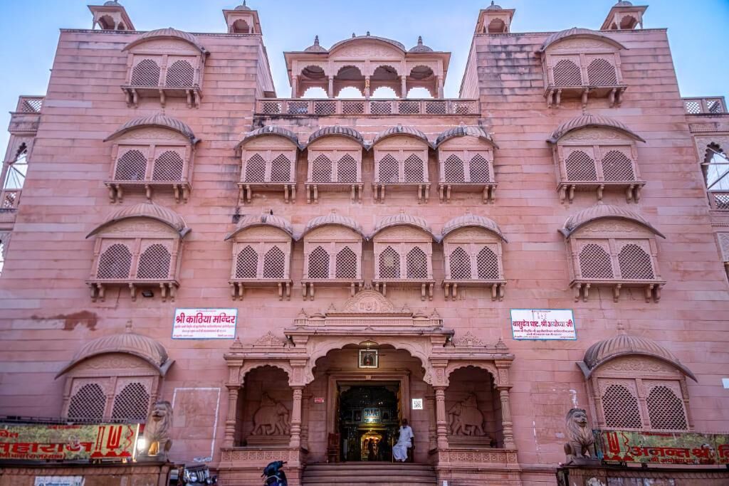 A pink building with multiple arched windows and a central entrance.