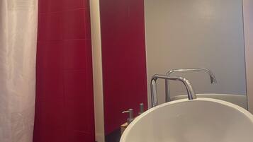 Een douche, handdoeken, zeep, toiletpapier