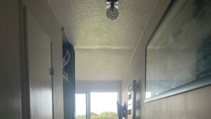 A corridor leading to a balcony with a view of the outdoors. - Sea view apartment facing the beach (Clohars-Carnoët)