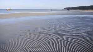 A beach with rippled sand patterns and a distant shoreline. - 4 Star Holiday Home in Glesborg (Glesborg)