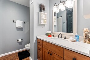 A bathroom with a white sink, wooden vanity, a large mirror, and a towel rack. - Kksr#4303 Direct Oceanfront, Top Floor, Ac, Remodeled, Sleeps 8 (KAILUA KONA)
