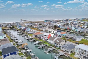 A coastal residential area with houses, docks, and a pier. - Spacious 4-bedroom Canal Home on Holden Beach (Holden Beach)