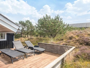 Eine Terrasse mit Liegestühlen und einer Holzdeckkante.