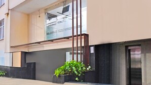 A modern building with a glass balcony, a staircase, and a door. - Deluxe With Twin Bed Hotel Amrit Plaza (Dhanbad)
