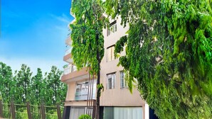 A multi-story building with balconies, surrounded by greenery. - Deluxe With Twin Bed Hotel Amrit Plaza (Dhanbad)
