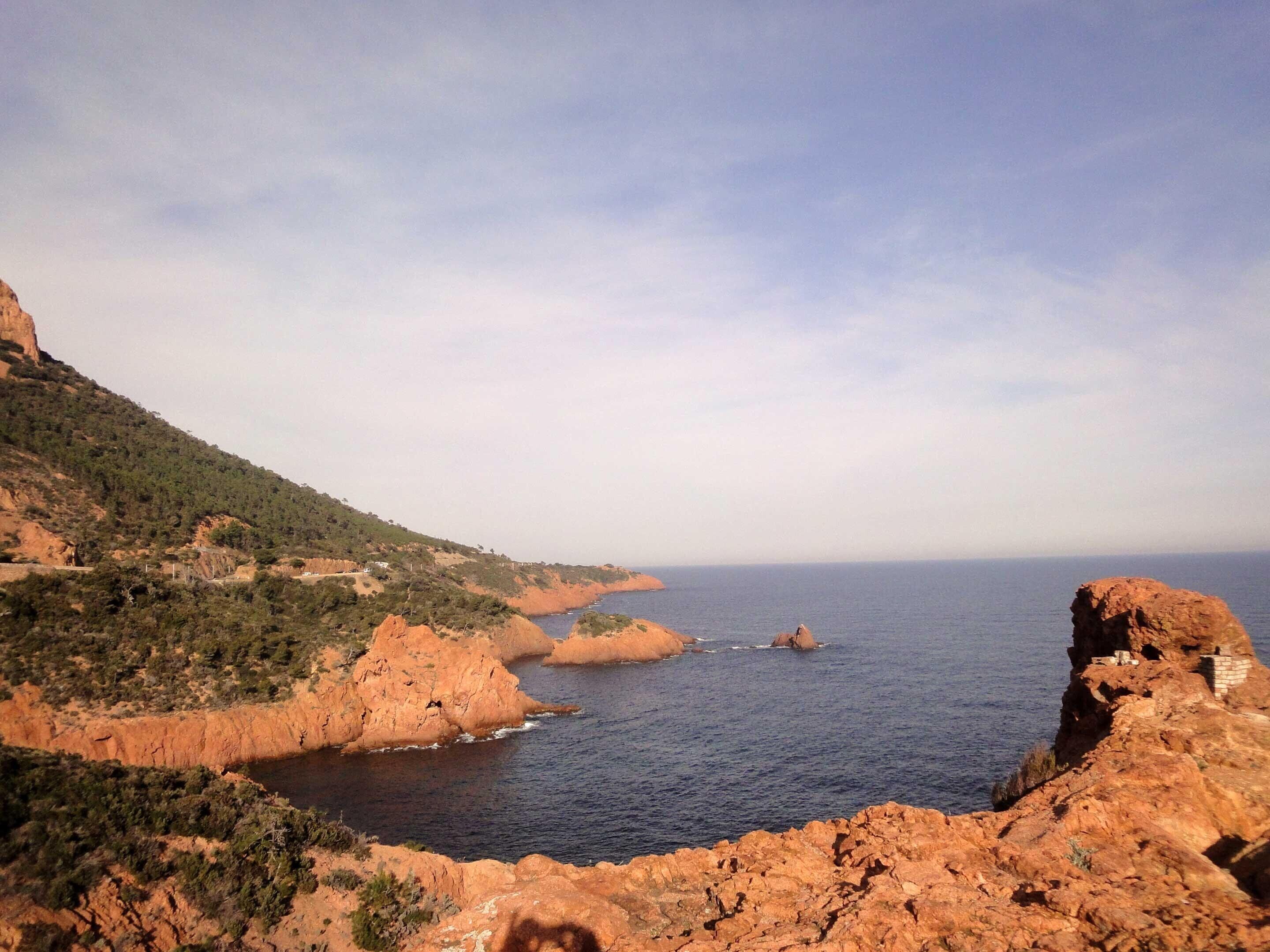 Eine Küstenlandschaft mit felsigem Gelände und Blick auf das Meer.